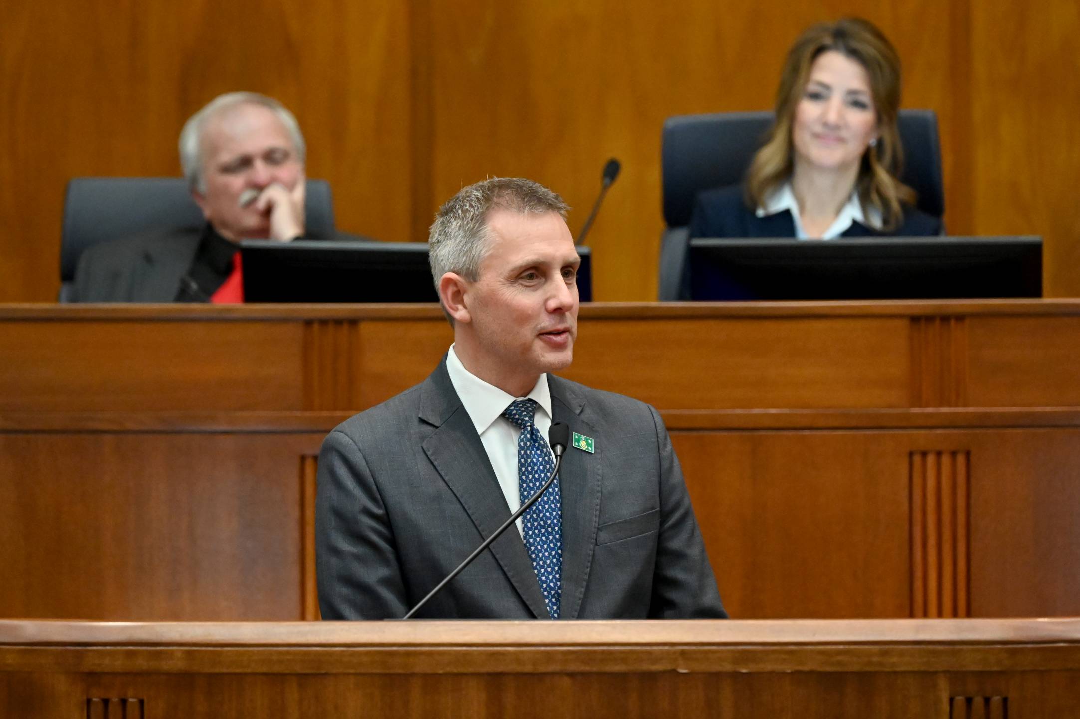 Governor Kelly Armstrong delivers his 2025 State of the State Address in the House chamber with Lt. Gov. Michelle Strinden and House Speaker Robin Weisz looking on behind him.